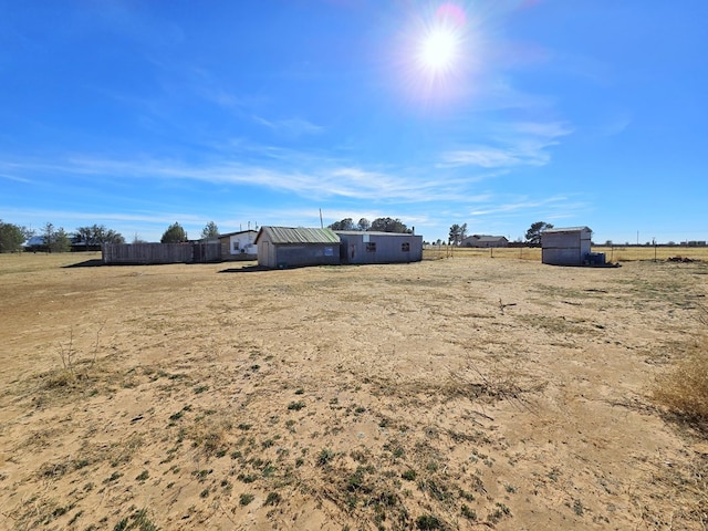 view of yard with a shed and a rural view