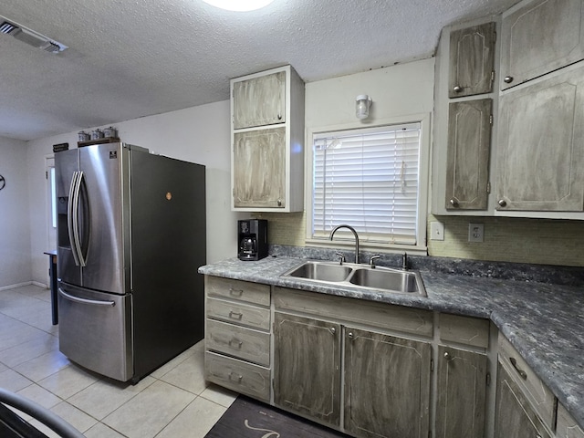 kitchen with light tile patterned floors, sink, backsplash, a textured ceiling, and stainless steel fridge with ice dispenser