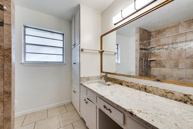 bathroom with toilet, vanity, tile patterned flooring, and tiled shower