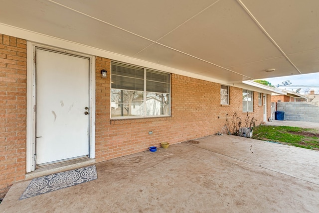 view of exterior entry with a patio area