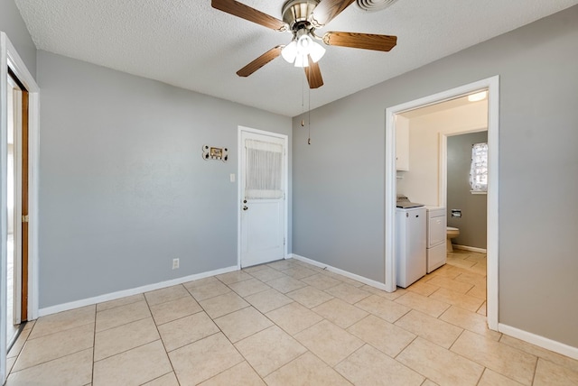 unfurnished bedroom featuring ceiling fan, separate washer and dryer, a textured ceiling, and ensuite bath