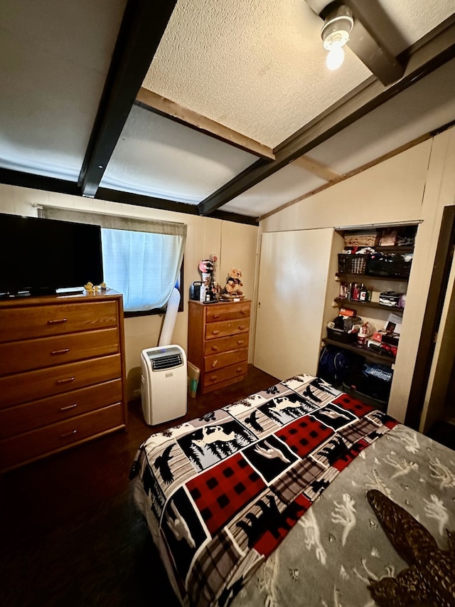 bedroom featuring beamed ceiling and a textured ceiling