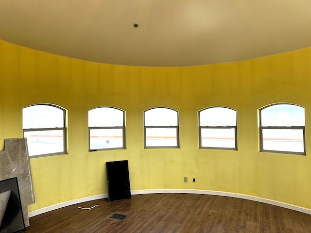 empty room with hardwood / wood-style flooring and a premium fireplace