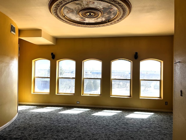 empty room featuring carpet flooring and plenty of natural light