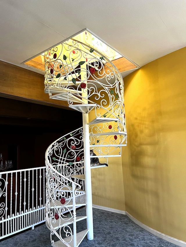 staircase featuring carpet floors and a textured ceiling