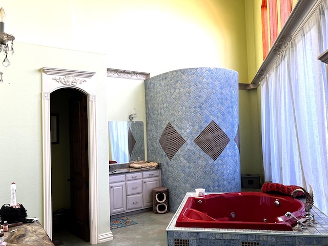 bathroom featuring vanity and a relaxing tiled tub