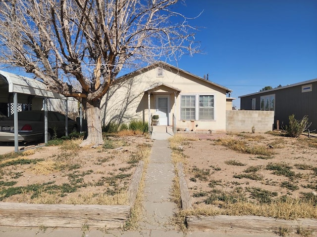 bungalow-style house with fence and stucco siding