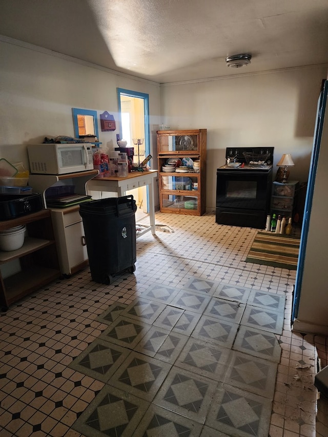 kitchen with a textured ceiling, white microwave, tile patterned floors, and black electric range oven