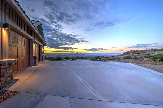 patio terrace at dusk with a mountain view and a garage