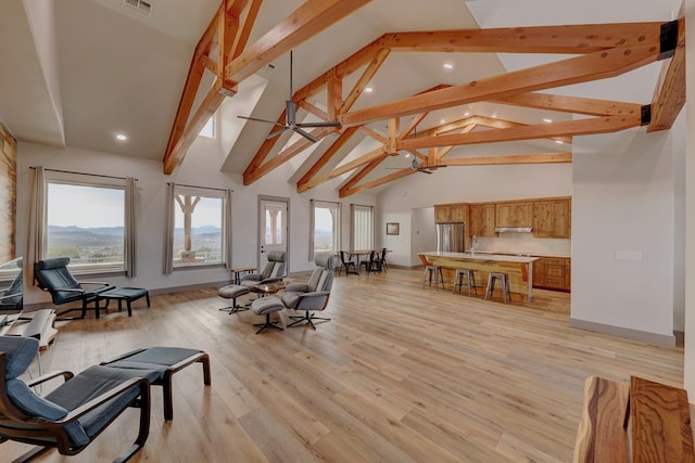 interior space with beam ceiling, ceiling fan, high vaulted ceiling, and light wood-type flooring