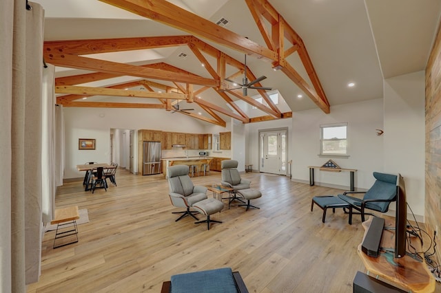 living room featuring beam ceiling, light hardwood / wood-style floors, and high vaulted ceiling