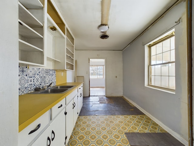 kitchen featuring white cabinetry, sink, and decorative backsplash