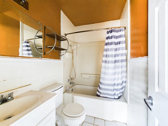 full bathroom with shower / tub combo with curtain, toilet, tile walls, vanity, and tile patterned flooring