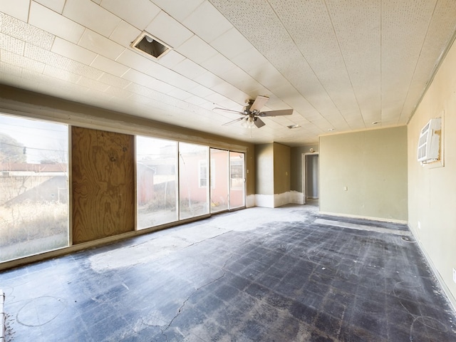 spare room with ceiling fan and a wall mounted air conditioner