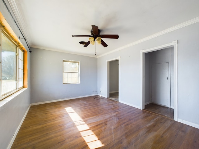 unfurnished bedroom featuring multiple windows, crown molding, dark hardwood / wood-style flooring, and ceiling fan