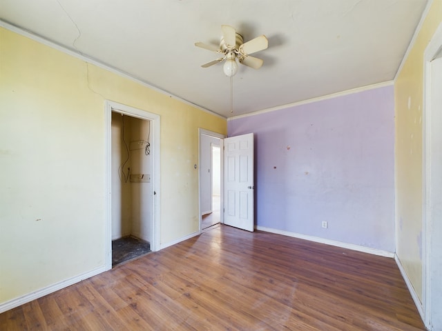 unfurnished bedroom featuring dark wood-type flooring, ornamental molding, a closet, and ceiling fan