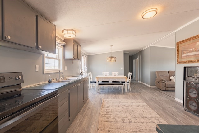 kitchen featuring sink, light hardwood / wood-style flooring, hanging light fixtures, and black electric range