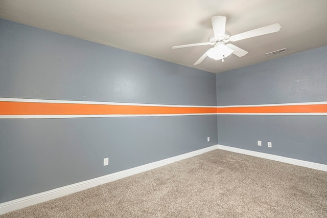 carpeted spare room with baseboards, visible vents, and a ceiling fan