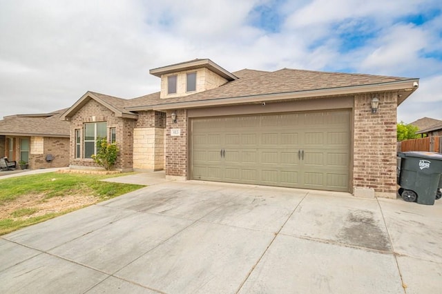 view of front of home with concrete driveway, brick siding, an attached garage, and roof with shingles