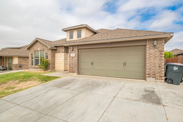 view of front of house featuring concrete driveway, brick siding, an attached garage, and roof with shingles