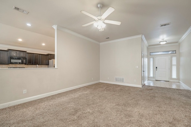 unfurnished living room featuring light carpet, ceiling fan, and crown molding