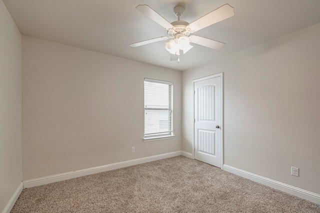 carpeted spare room featuring ceiling fan