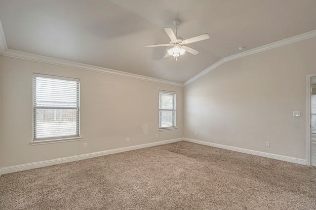 carpeted spare room featuring lofted ceiling, ornamental molding, a ceiling fan, and baseboards