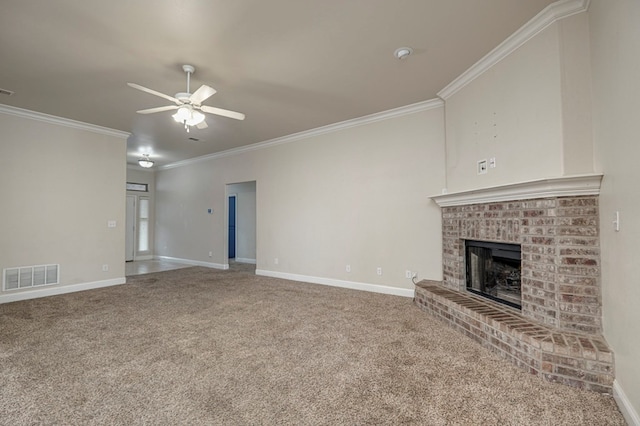 unfurnished living room featuring ceiling fan, carpet floors, a fireplace, visible vents, and crown molding