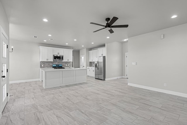 kitchen with white cabinetry, tasteful backsplash, an island with sink, ceiling fan, and stainless steel appliances