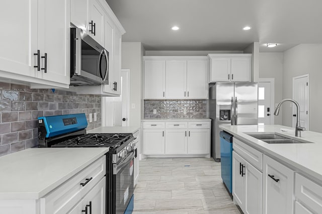 kitchen featuring white cabinetry, appliances with stainless steel finishes, sink, and backsplash