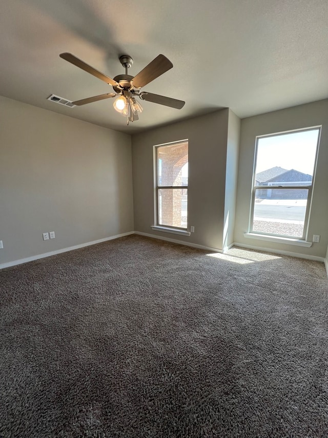 carpeted spare room featuring ceiling fan