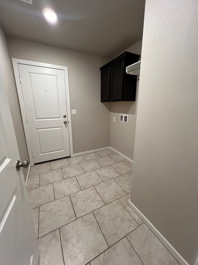 washroom with washer hookup, cabinets, and light tile patterned floors