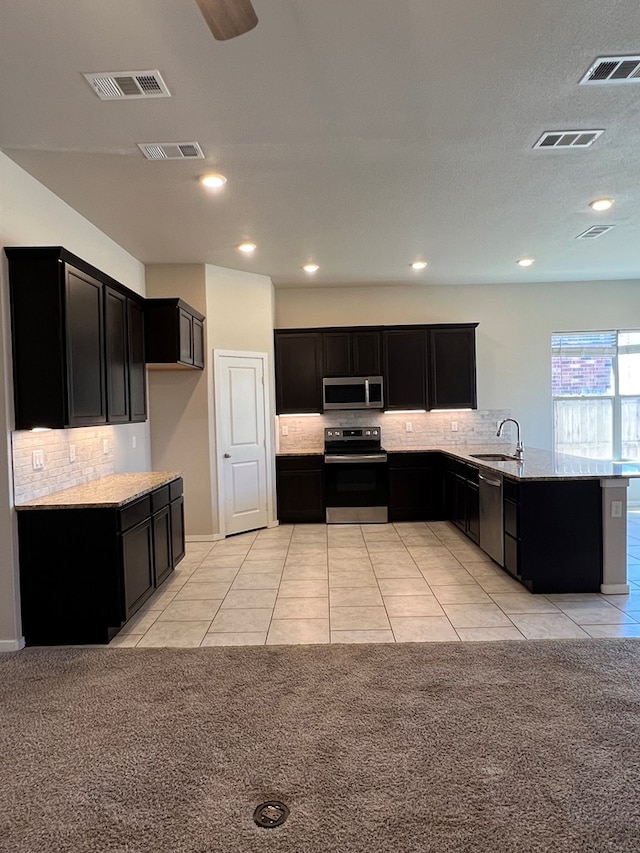 kitchen featuring light carpet, stainless steel appliances, tasteful backsplash, and sink