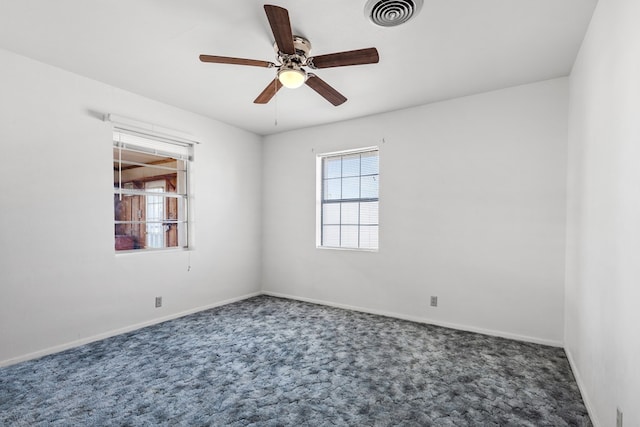 unfurnished room with dark carpet and ceiling fan