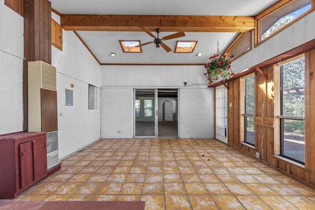 interior space with electric panel, ceiling fan, vaulted ceiling with skylight, and a healthy amount of sunlight