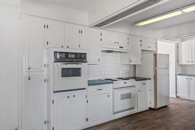 kitchen featuring tasteful backsplash, white cabinets, dark wood-type flooring, and white appliances