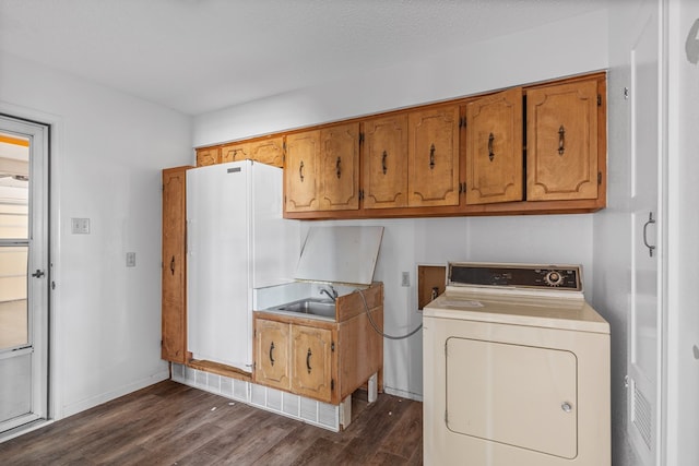 laundry room featuring sink, cabinets, dark hardwood / wood-style flooring, a textured ceiling, and washer / dryer