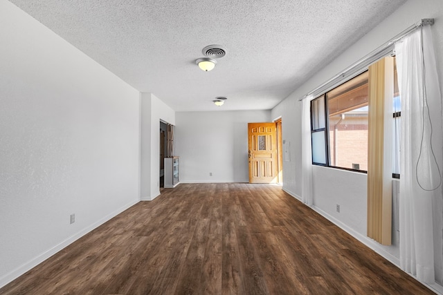 interior space featuring a textured ceiling and dark hardwood / wood-style floors