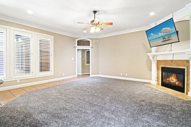 unfurnished living room featuring crown molding, ceiling fan, tile patterned floors, and a high end fireplace