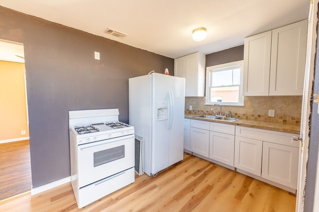 kitchen featuring white cabinetry, sink, white appliances, and decorative backsplash