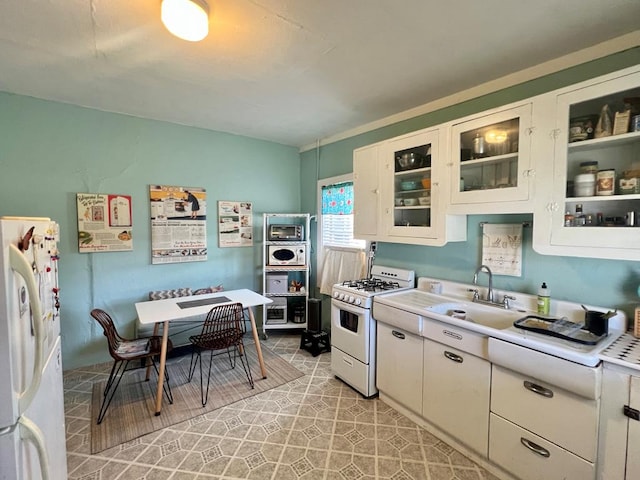 kitchen with sink, white appliances, white cabinets, and light tile patterned floors