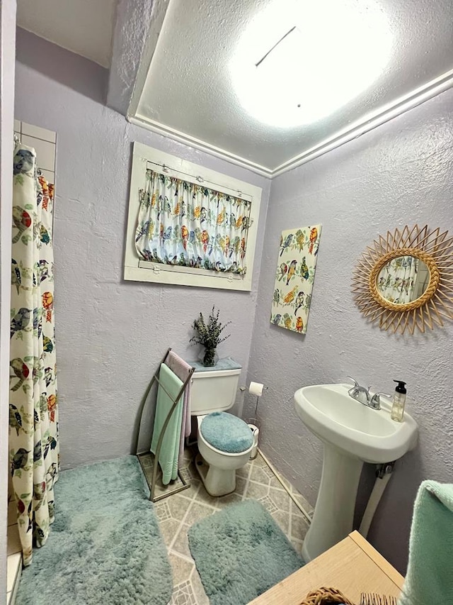 bathroom with a shower with curtain, toilet, tile patterned floors, and crown molding