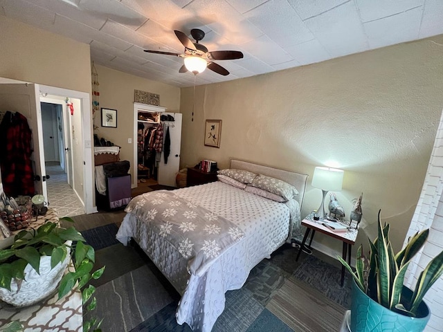 bedroom featuring a closet, ceiling fan, and a walk in closet