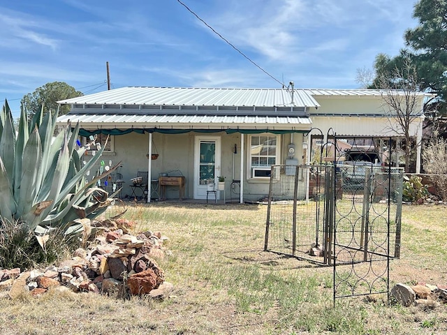 rear view of property featuring a lawn