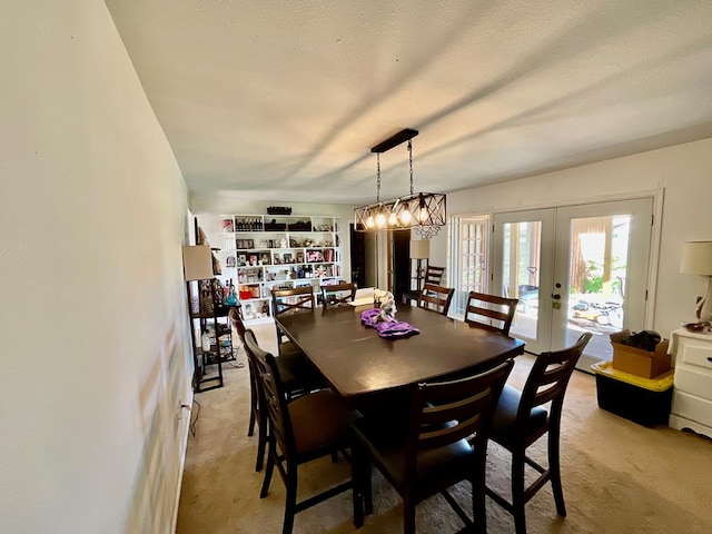 dining space featuring light carpet, french doors, and a textured ceiling