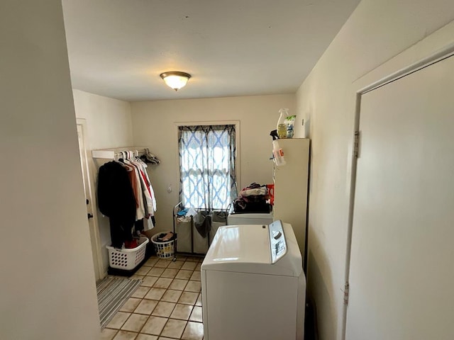 clothes washing area with washer and clothes dryer and light tile patterned floors