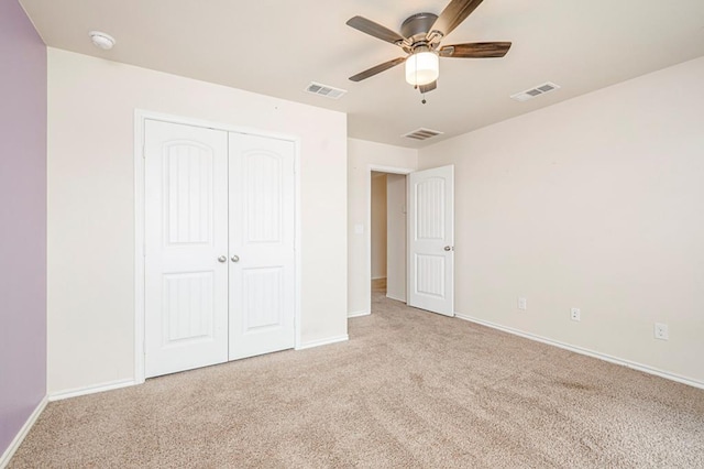 unfurnished bedroom featuring light carpet, ceiling fan, and a closet