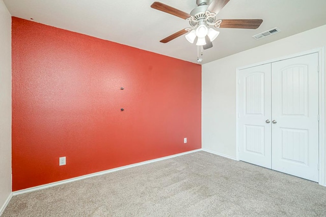 unfurnished bedroom with light carpet, ceiling fan, and a closet