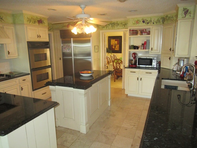 kitchen featuring appliances with stainless steel finishes, a center island, ceiling fan, and sink