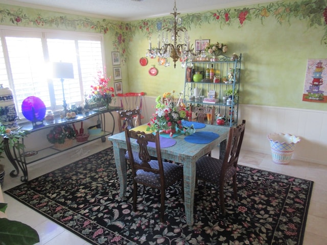 tiled dining space featuring a chandelier, a textured ceiling, and ornamental molding